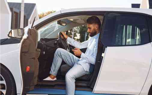 Black man parked and sitting in car texting